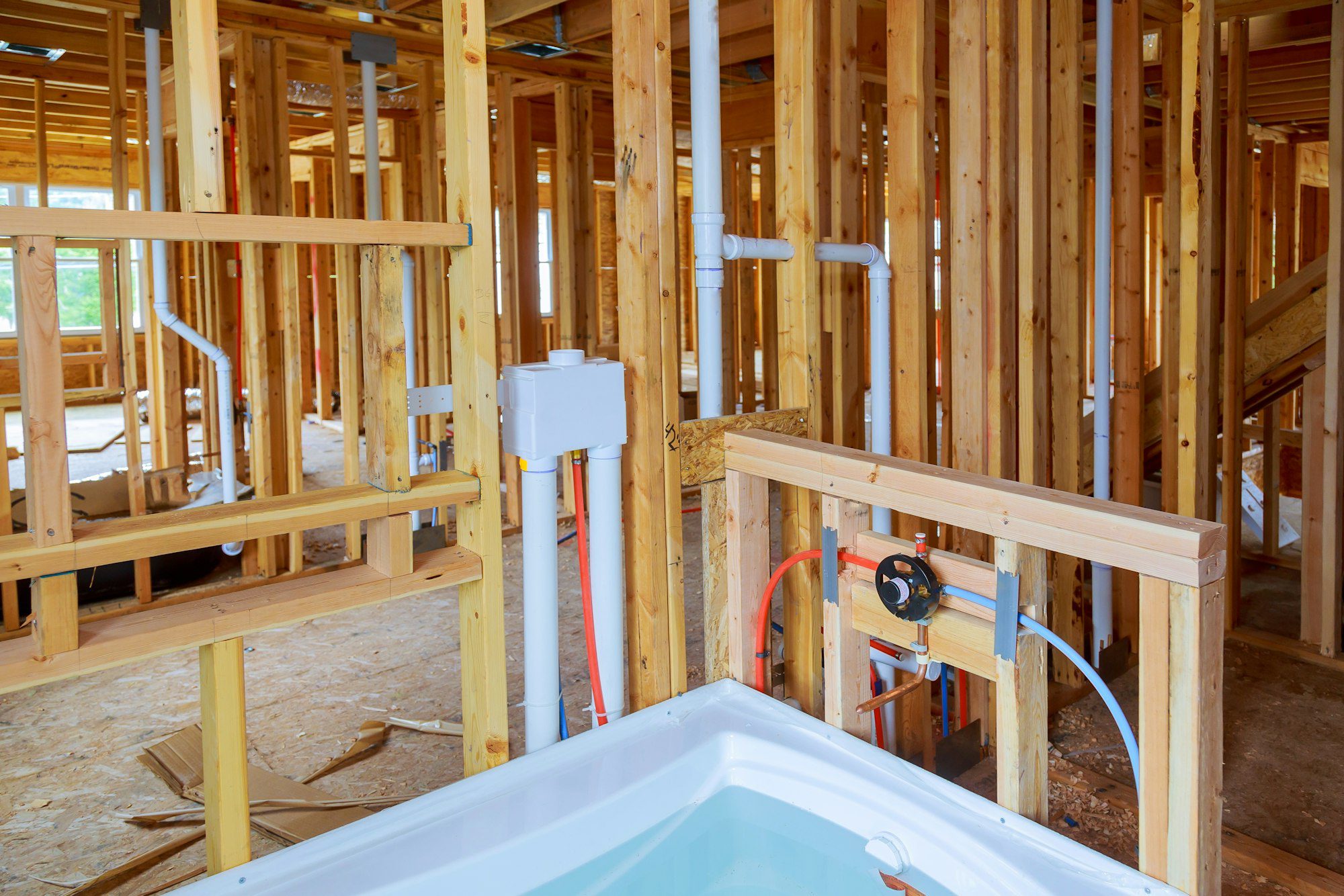 Interior wall framing with piping and bathroom installed Plumbing pipes and exposed beams.